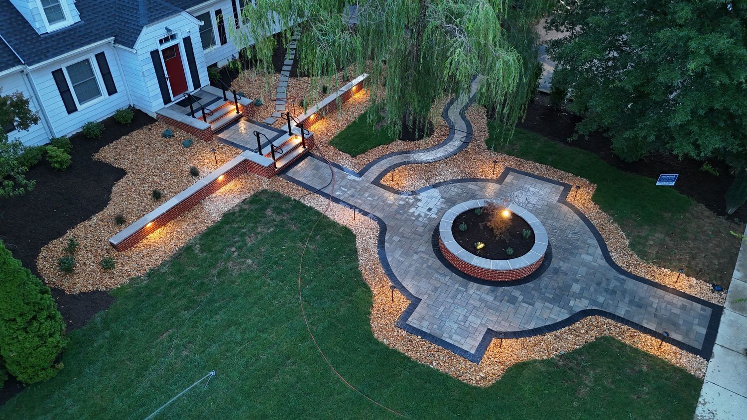 paver patio with a large concrete landscaping pit in the middle